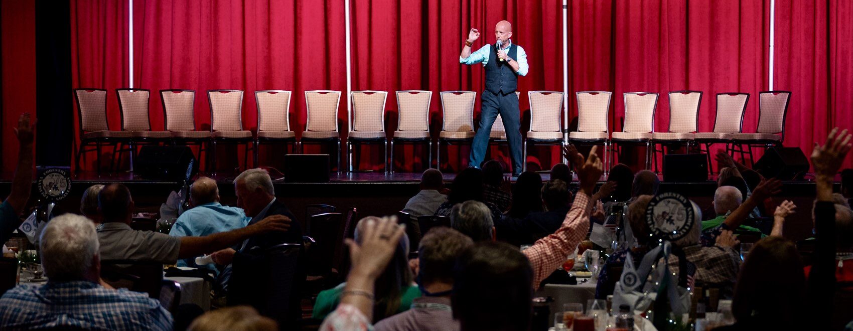Corporate entertainment hypnosis show. Stage Hypnotist Erick Kand on stage in front of a corporate audience.